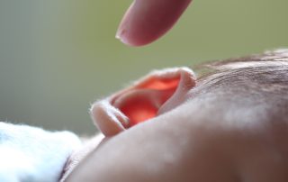 Doigt pointant l'oreille d'un enfant